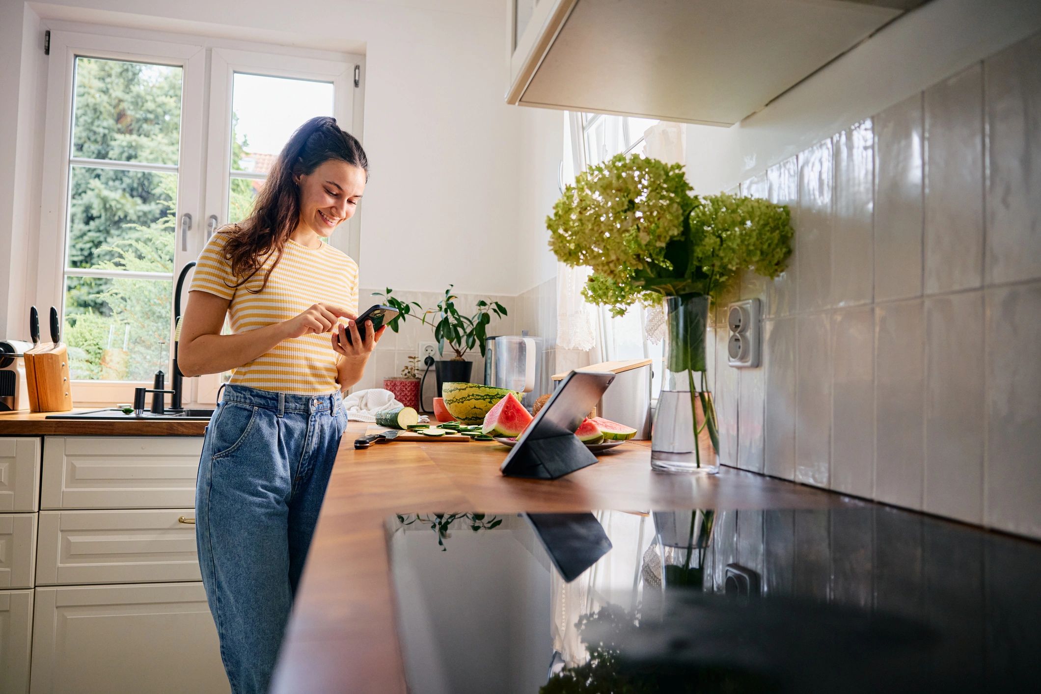 Home cook checking a recipe while preparing a meal in the kitchen